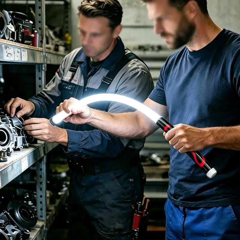 Two workshop users inspecting mechanical parts under a flexible LED light